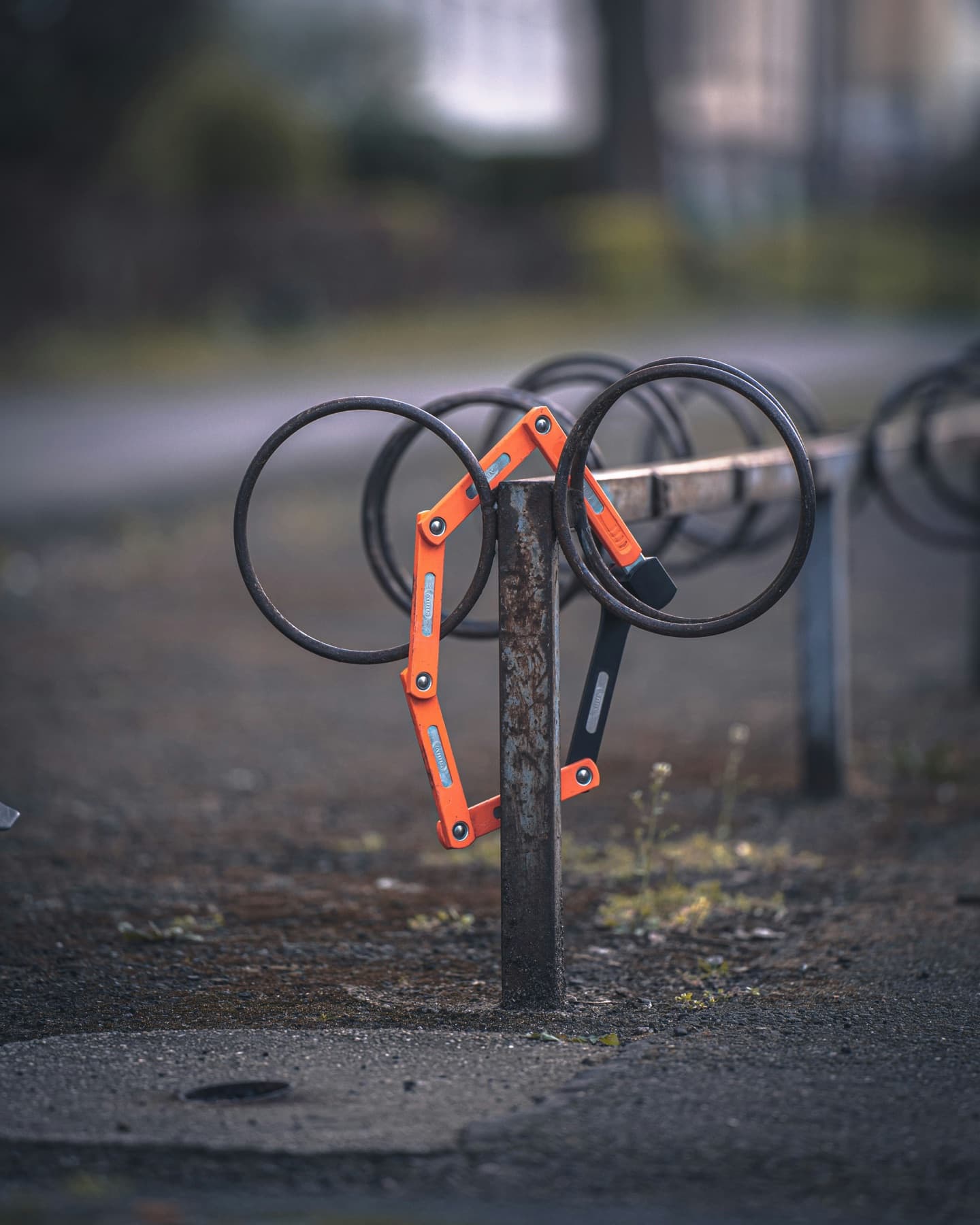Zurückgelassenes Faltschloss am leeren Fahrradständer